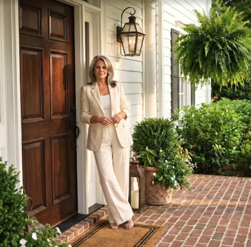 Leslie Huggins standing on a front porch in a light suit